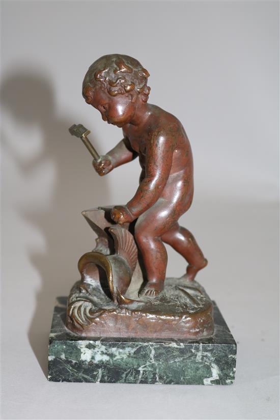 Henri Capy. A bronze figure of a putto forging an arrow, 6in.